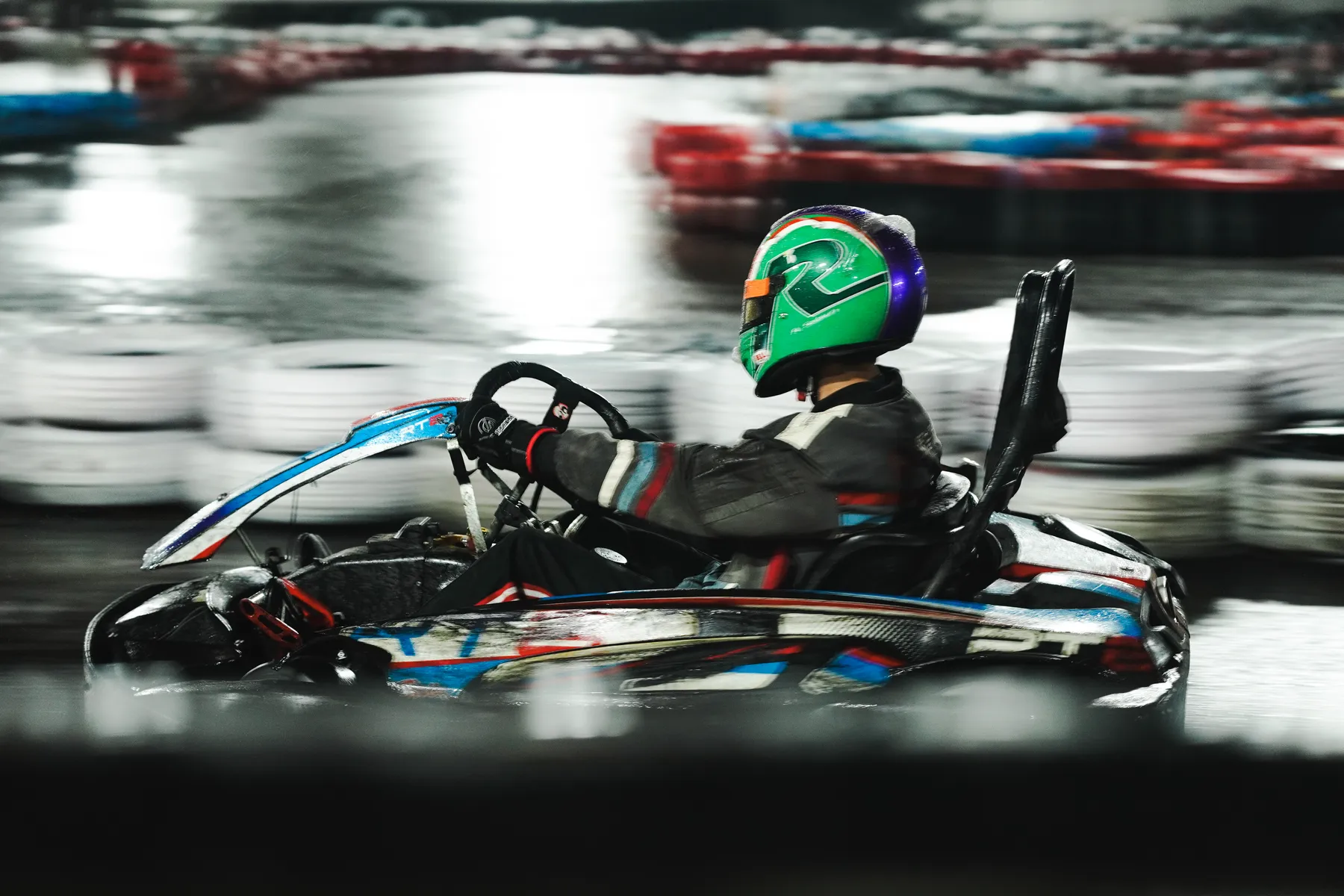 Kart sliding through a wet corner, side profile